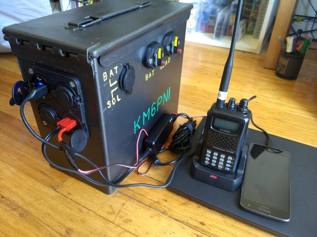 Battery box charging a laptop, phone, and handheld radio