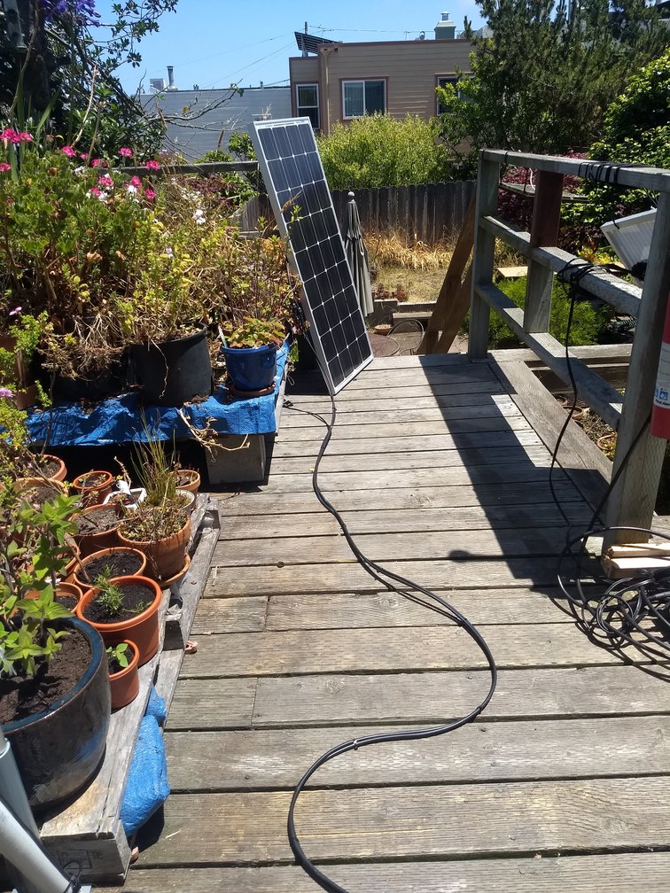 A solar panel sitting in a deck garden